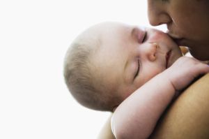 Mother kissing sleeping infant