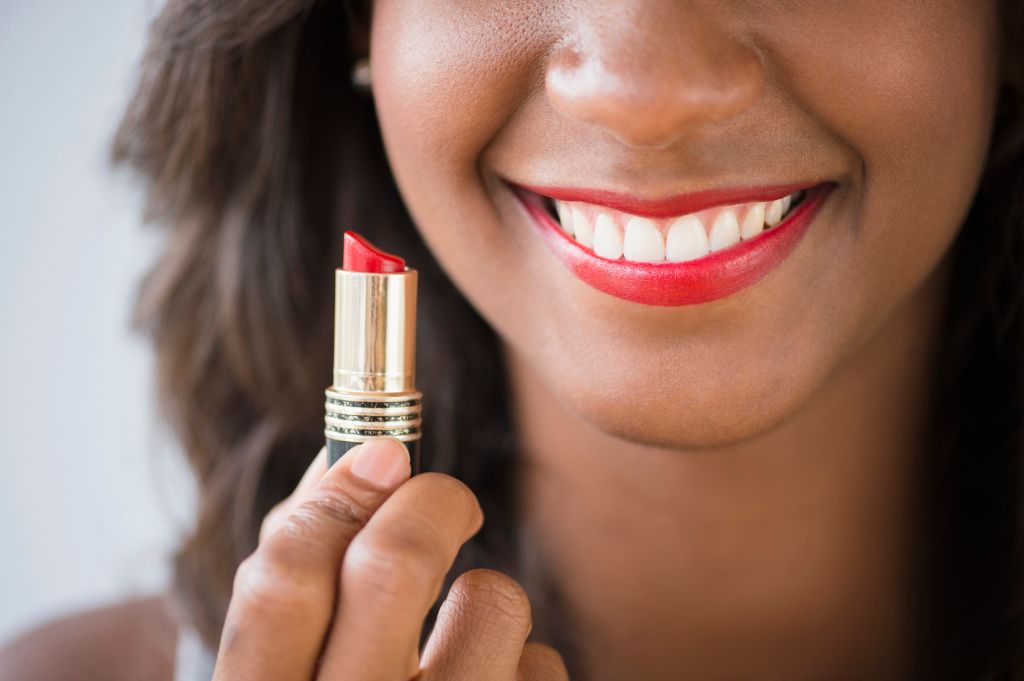 Black woman holding lipstick
