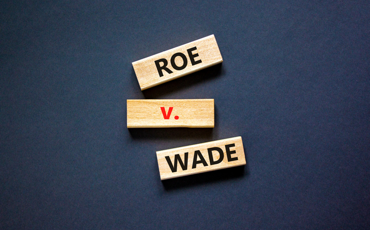 Abortion process Roe versus Wade symbol. Concept words Roe versus Wade on wooden blocks. Beautiful black table black background. Abortion process Roe versus Wade concept. Copy space.