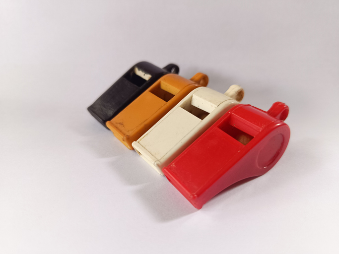 Four plastic whistles in various colors, usually used for various activities.