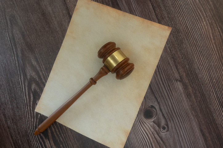 Judicial gavel resting on Vintage Parchment Paper Antique Writing and Calligraphy Concept